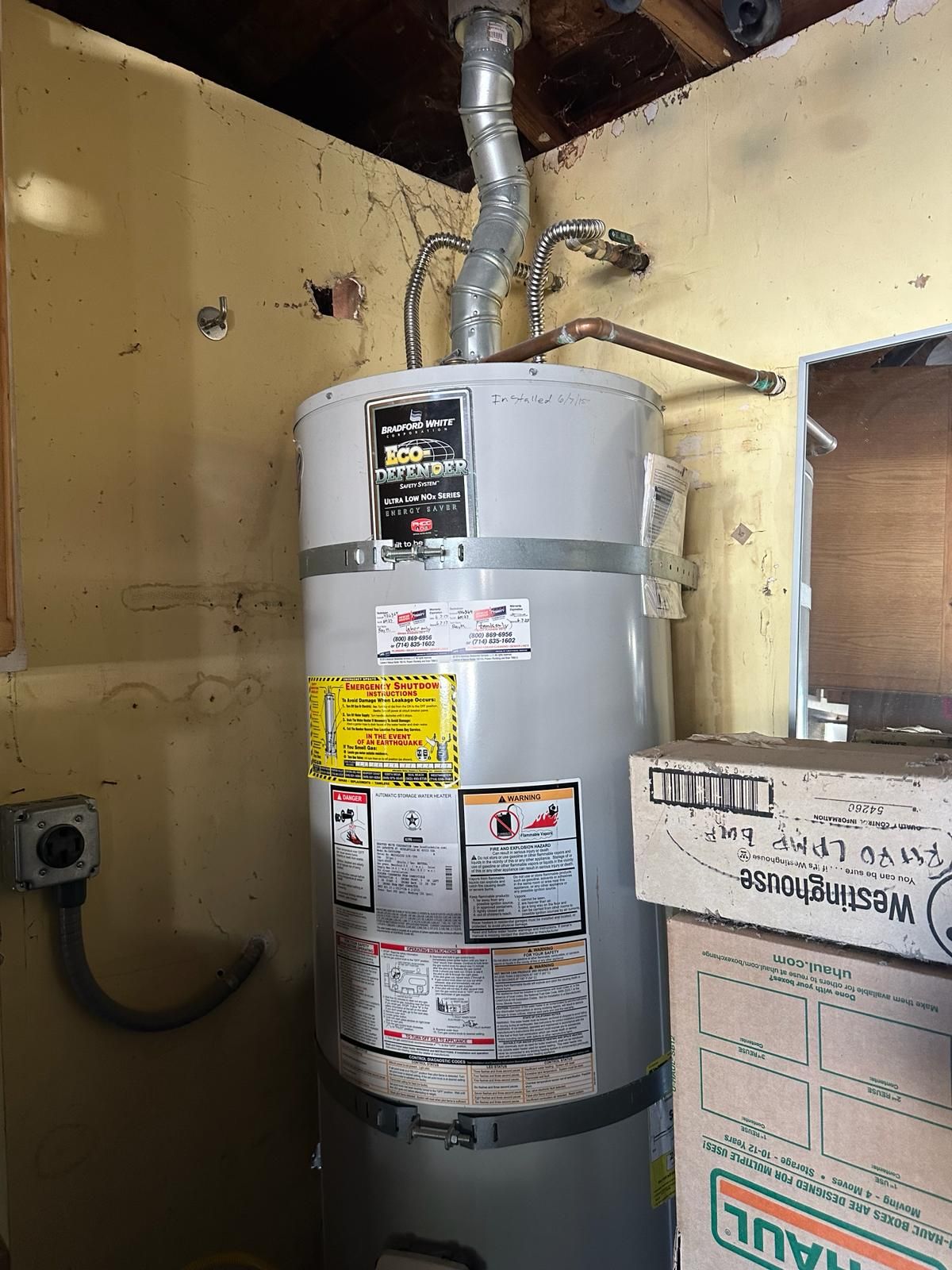 Gas water heater installed to code with earthquake straps and the install date written on the tank
